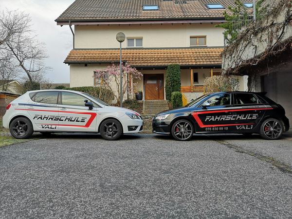 Fahrschulautos Seat Ibiza FR und Audi vor einem Haus